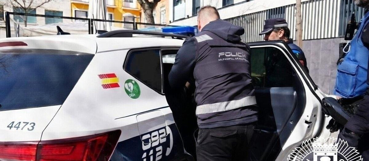 Agentes de la Policía Municipal de Madrid junto a un coche patrulla