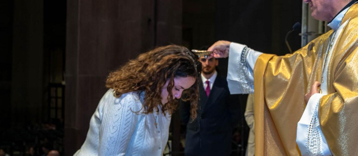 Saray, recibiendo el bautismo de manos del obispo auxiliar de Barcelona Javier Vilanova