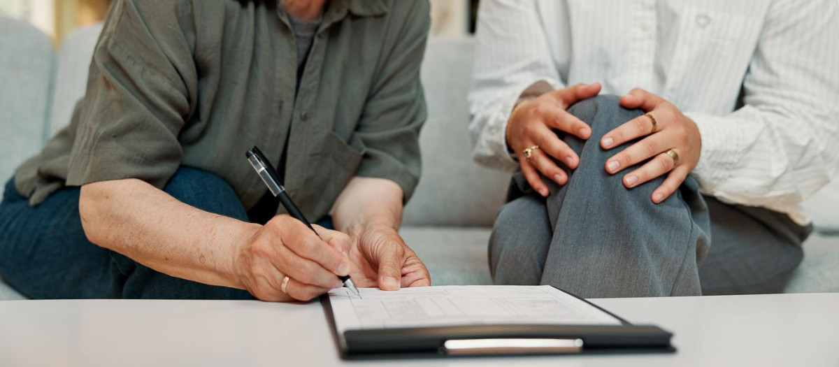 Lawyer, hands of old woman and sign paperwork in home for life insurance, title deed or agreement. Retirement, professional or senior client with signature for policy consent or legal form compliance
