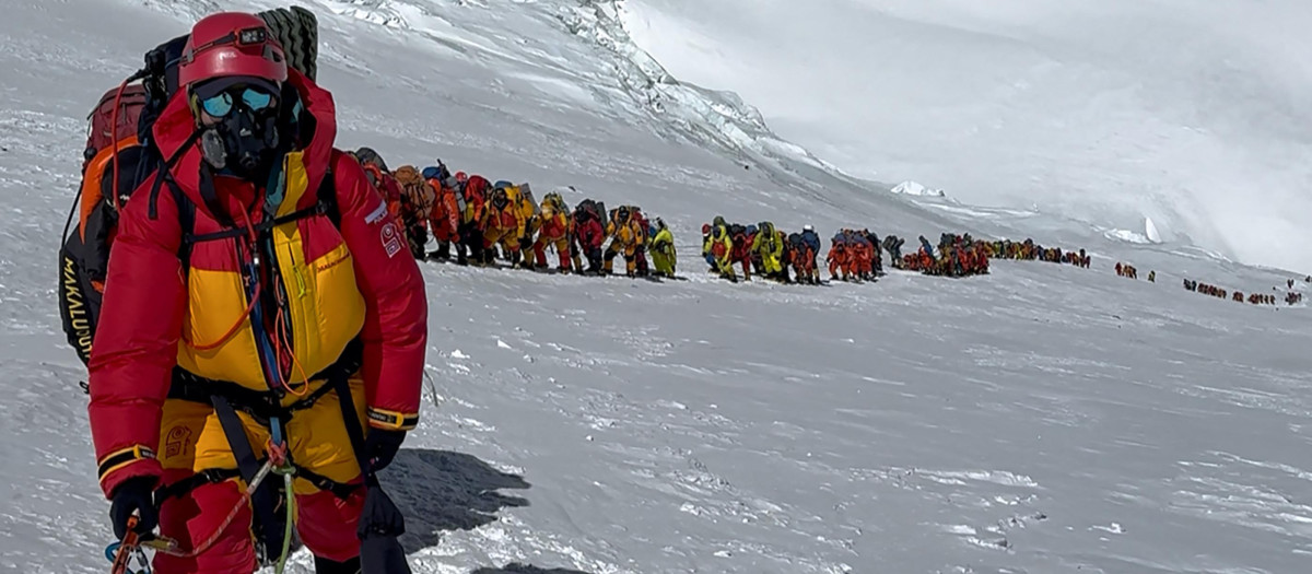 montañeros alineándose en una ladera durante su ascenso a la cima del Monte Everest en Nepal.