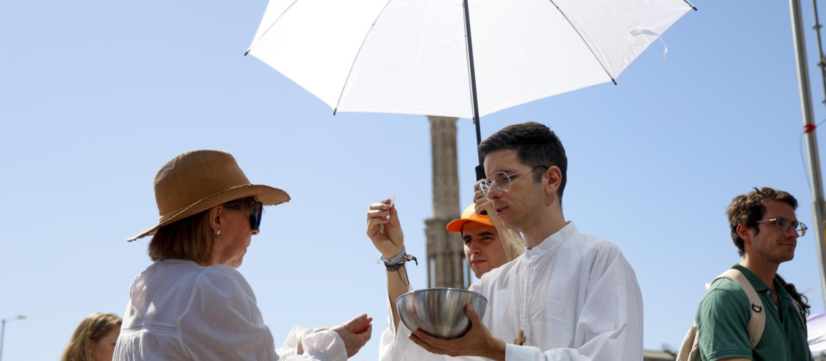 Sacerdote da de comulgar a una peregrina en la misa oficiada por el Papa León XIV