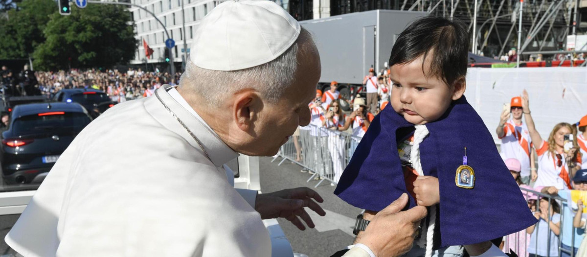 León XIV acoge a un niño antes de llegar a la misa de ayer domingo en Cibeles