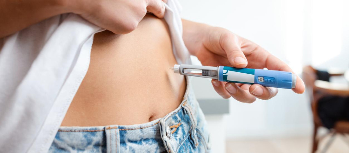Image of an individual injecting insulin into their abdomen using a pen device. Demonstrates healthcare, diabetes management, and medication administration domestically, conveying a sense of responsibility and self-care.