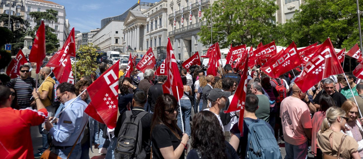 Varias personas con pancartas y banderas durante una concentración organizada por CCOO.