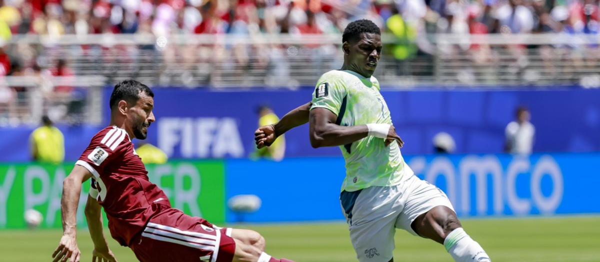Yusuf Abdurisag,de Qatar, pelea un balón con Breel Embolo, de Suiza