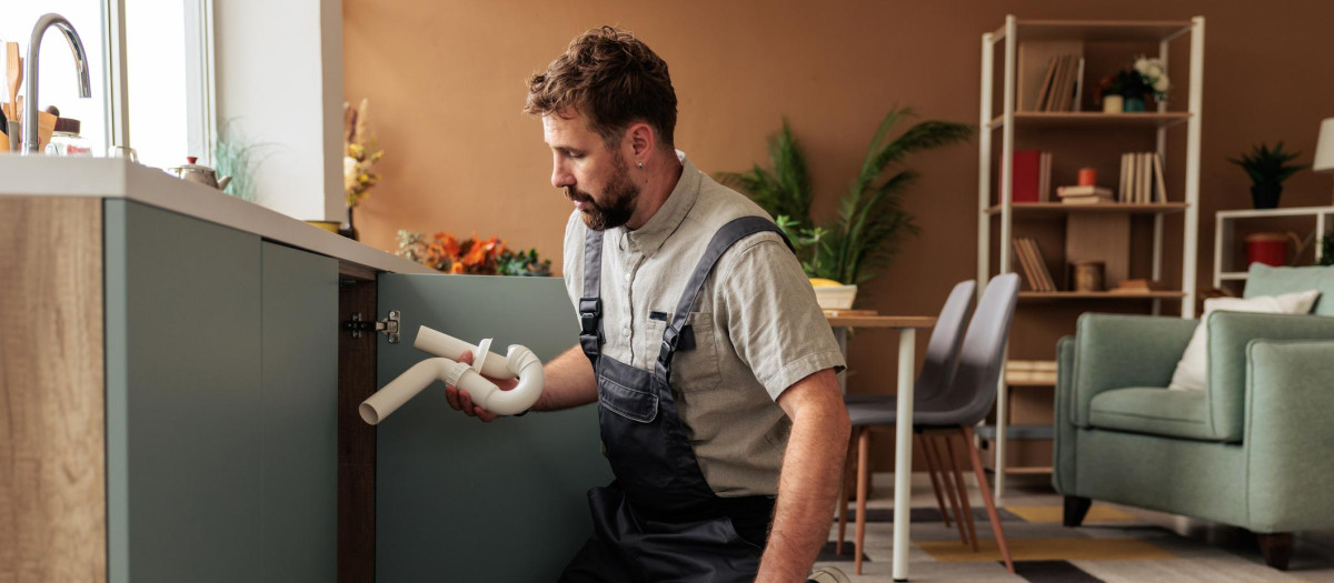 Un fontanero trabajando en la cocina