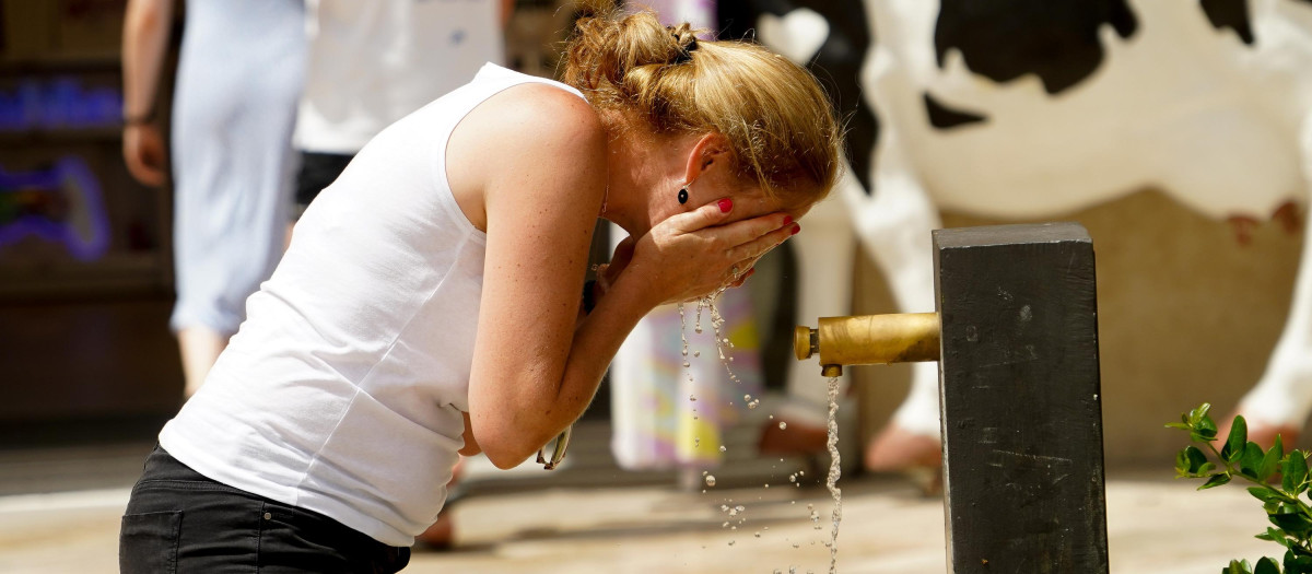 Imagen de una mujer refrescándose ante el calor en Valencia