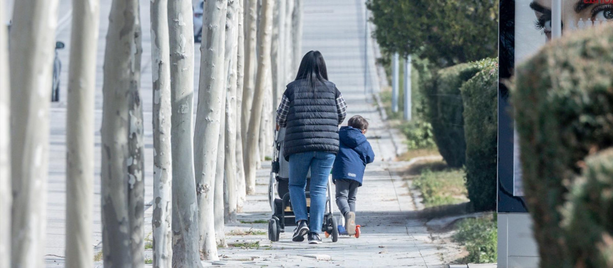Una mujer lleva un carrito de bebé en Madrid.