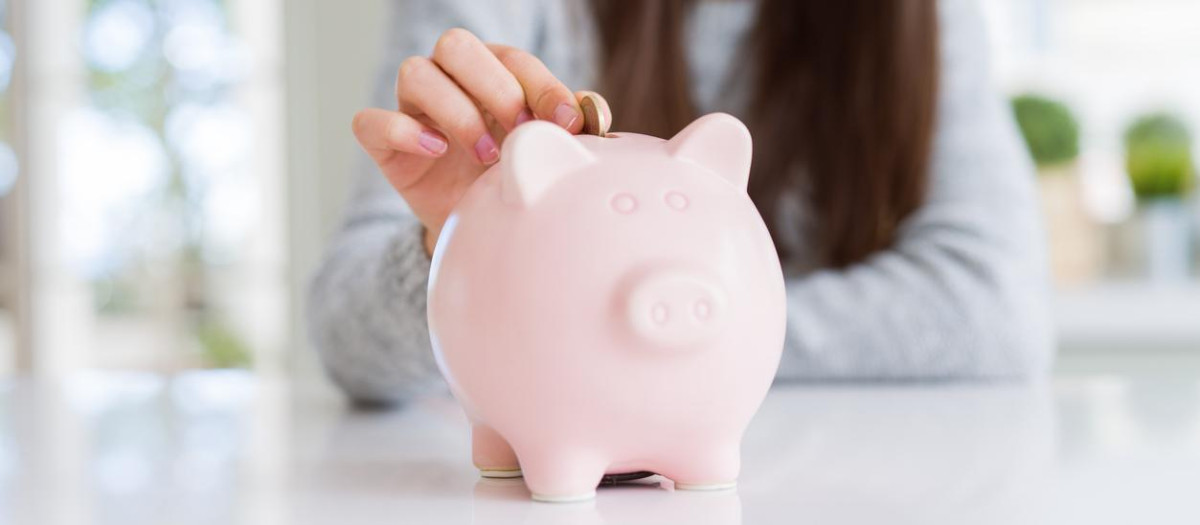 Una joven metiendo dinero en una hucha