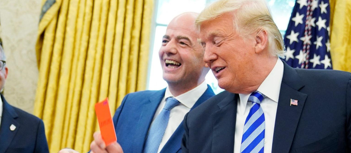 El presidente de la FIFA, Gianni Infantino (centro), ríe mientras el presidente de EE.UU., Donald Trump, sostiene una tarjeta roja