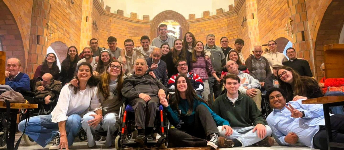 Varios grupos de jóvenes voluntarios posan con algunos de los residentes en la casa de Alcuéscar (Cáceres)