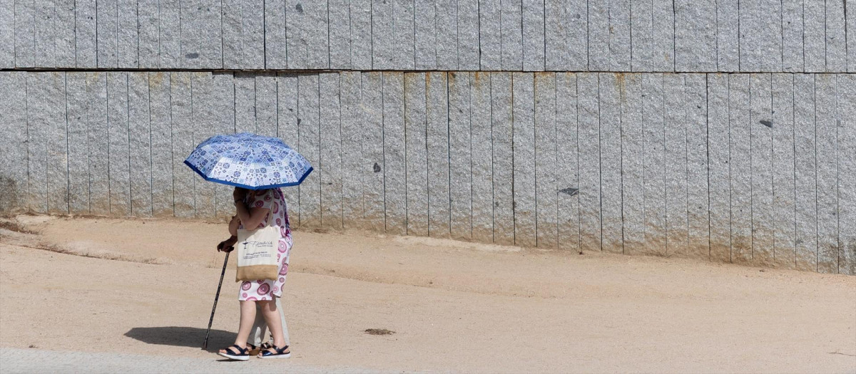 Personas afectadas por el calor pasean por Madrid Río