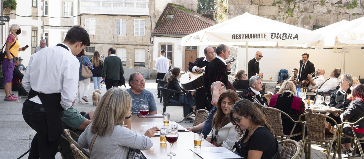 Un grupo de turistas consulta una carta en la terraza de un bar en Santiago de Compostela