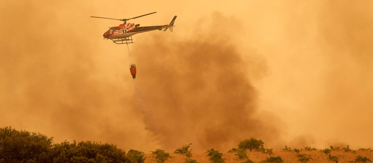 Un helicóptero lanza agua para intentar apagar el incendio de Ávila