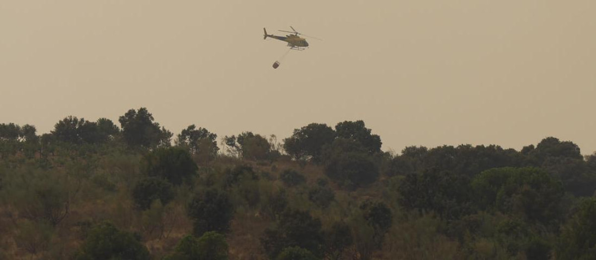 Un helicóptero del servicio de Bomberos trabaja en la extinción del incendio producido en la localidad madrileña de Pelayos de la Presa
