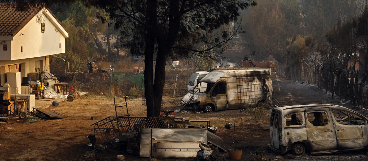 Varios coches calcinados yacen en el patio de una vivienda tras el incendio forestal que arrasó Pelayos de la Presa, a 65 kilómetros al oeste de Madrid, el 26 de julio de 2026.