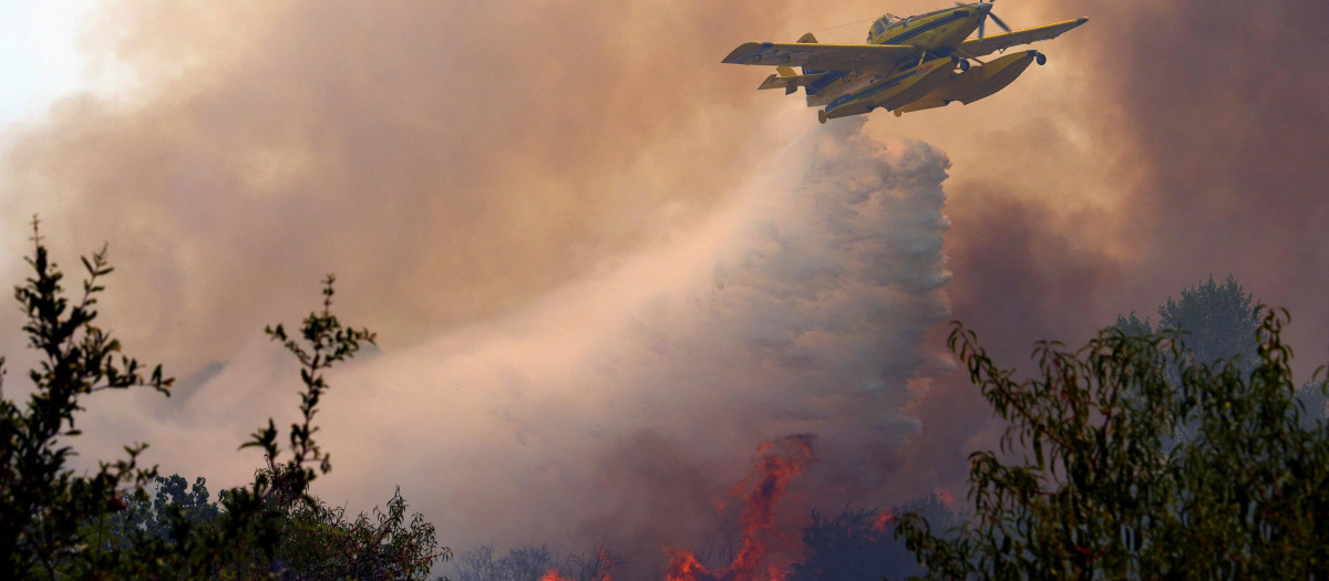 An Air Tractor AT-802F Fire Boss aircraft dumps water over a wildfire burning near San Martin de Valdeiglesias, about 70km west of Madrid, on July 26, 2026. Spanish firefighters today battled a new front of fires near the coastal city of Valencia, where at least 15,000 people were evacuated. In the western Madrid region, two separate wildfires merged on July 24 into a massive blaze that nearly joined another fire in neighboring Castile and Leon. The flames have already burned 25,000 hectares across Madrid and neighboring Avila province, forcing more than 60,000 people (a downwardly revised figure) to flee their homes, according to authorities, who labeled the fire the "worst in history" for the Madrid region. (Photo by Cesar MANSO / AFP)