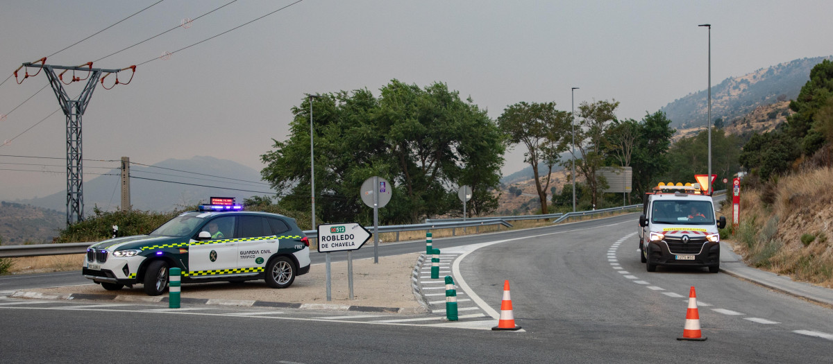Vehículos de la guardia civil vigilan la carretera cortada durante las labores de extinción del incendio forestal, a 25 de julio de 2026, en Robledo de Chavela