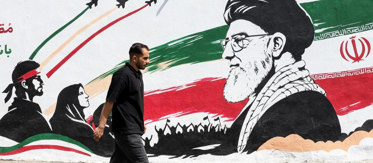 Un hombre pasa frente a un mural que representa al difunto líder supremo iraní, el ayatolá Ali Jamenei, en Teherán