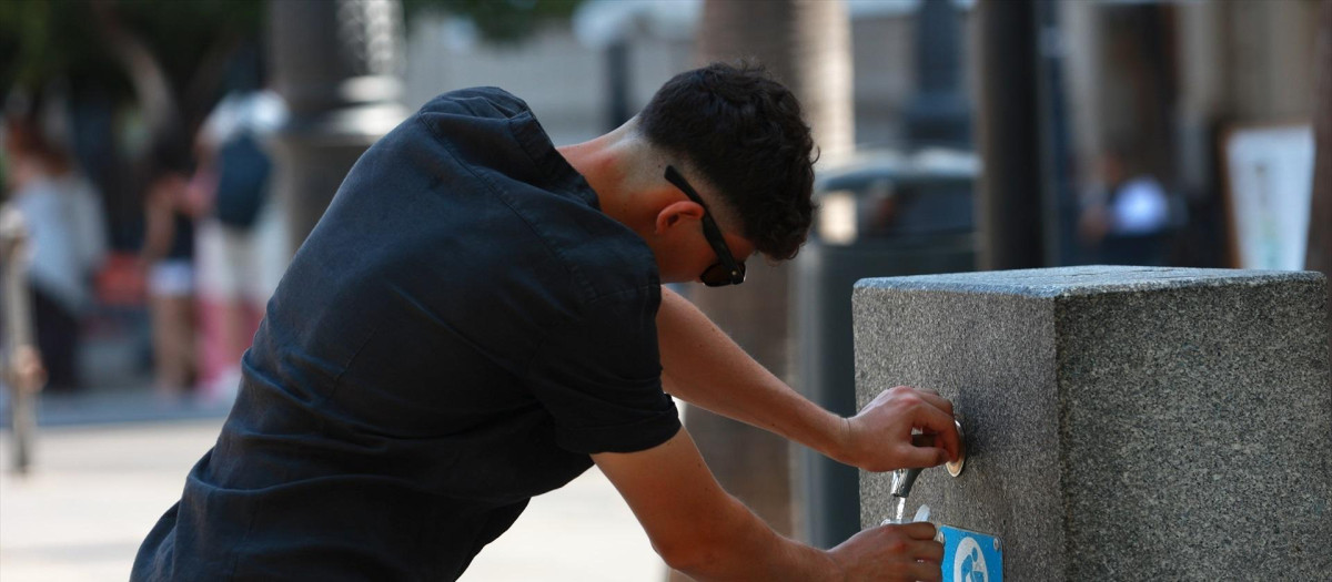 Una persona se refresca en una fuente