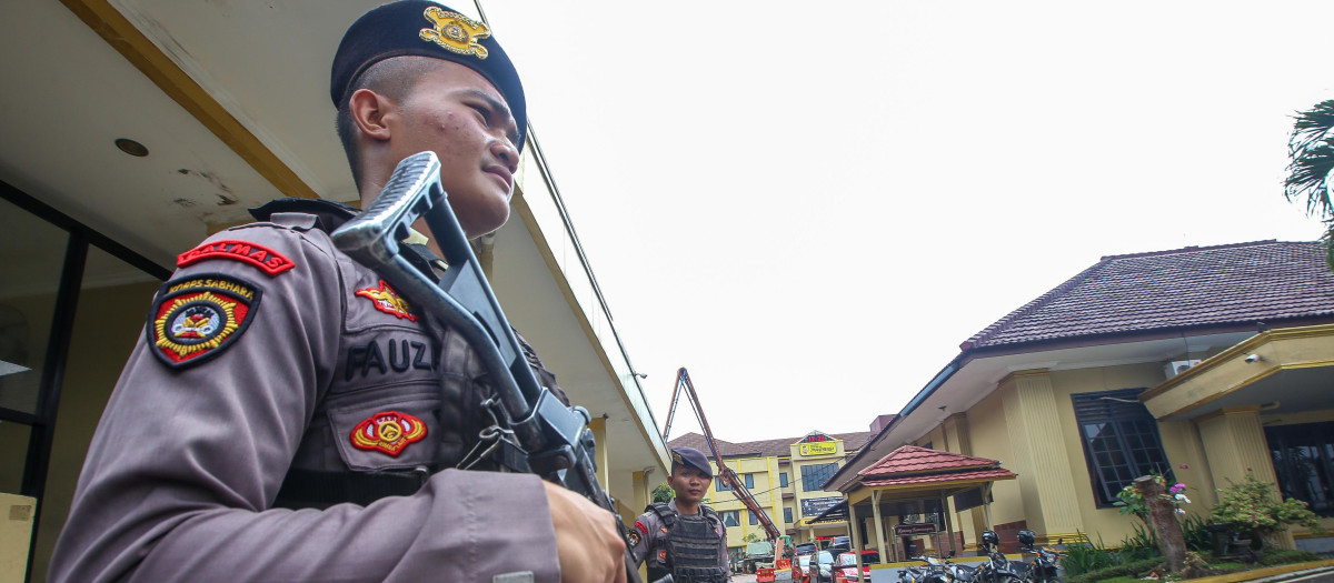 Members of the Bogor City Police stand guard at the entrance of the police station after a suicide bombing at Astanaanyar Police Station, Bandung City.