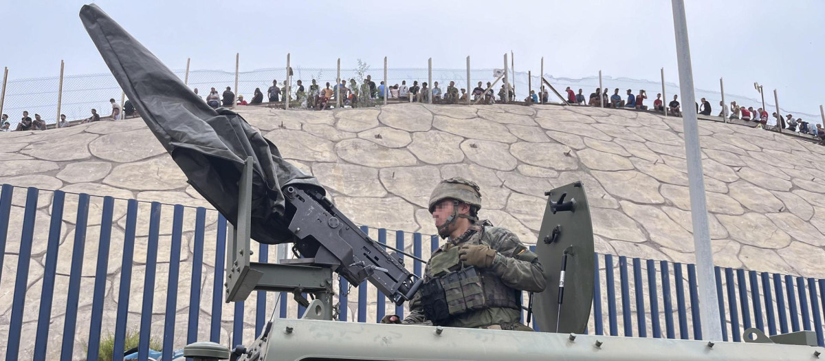 El ejército desplegando en la frontera del Tarajal en Ceuta ante la atenta mirada de los inmigrantes este viernes, donde se han registrado violentos enfrentamientos en los perímetros fronterizos durante su intento de acceder desde Marruecos hacia Ceuta y Melilla