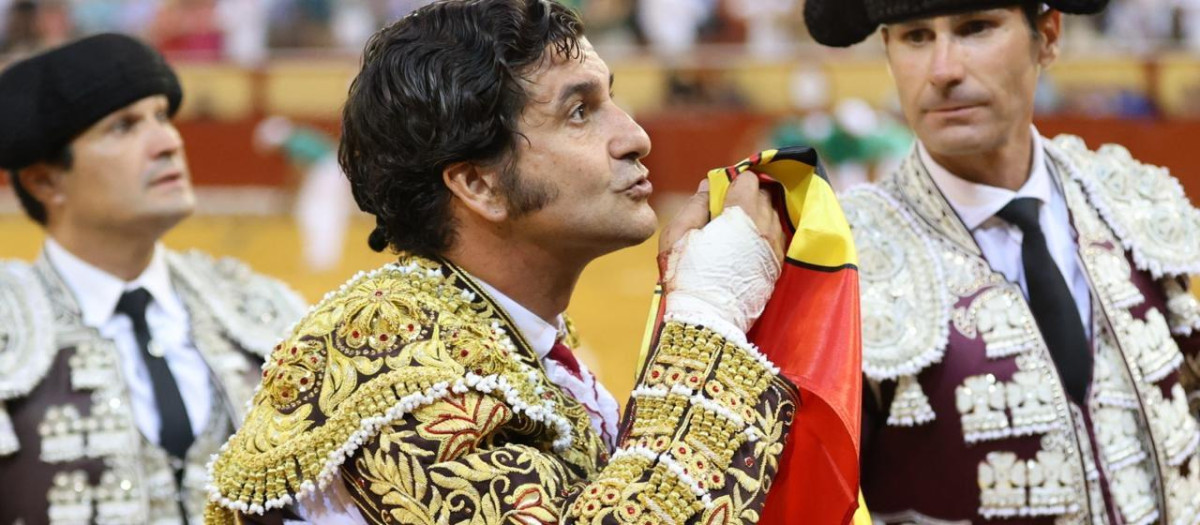 Morante de la Puebla besa una bandera recogida con su mano maltrecha tras el percance sufrido en Palma de Mallorca