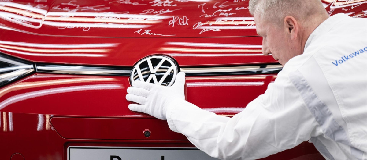Un empleado de Volkswagen, junto al último ID.3 fabricado en la Fábrica Transparente de Sajonia, Alemania.