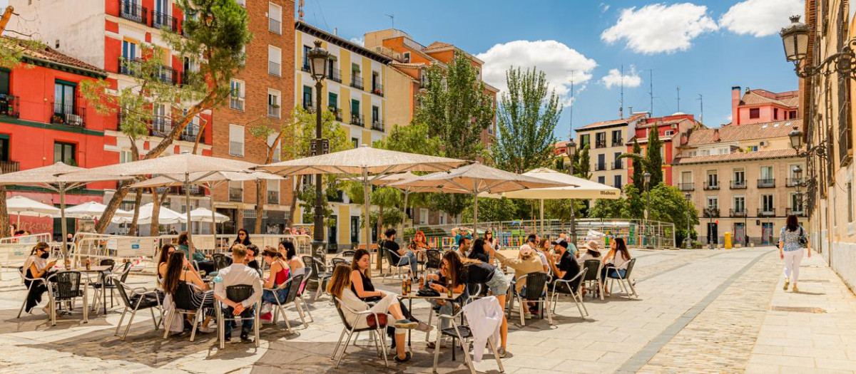 June, 2021. Madrid, Spain. A sunny day in the old town of Madrid with several young people, colorful buildings and deep blue sky with few clouds.