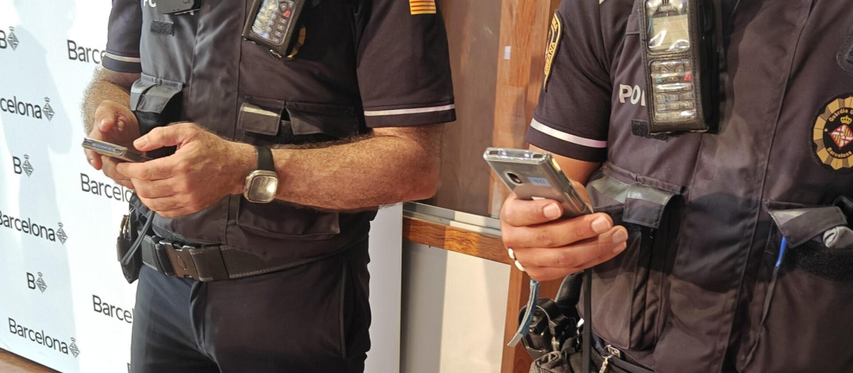 Dos agentes de la Guardia Urbana muestran los dispositivos