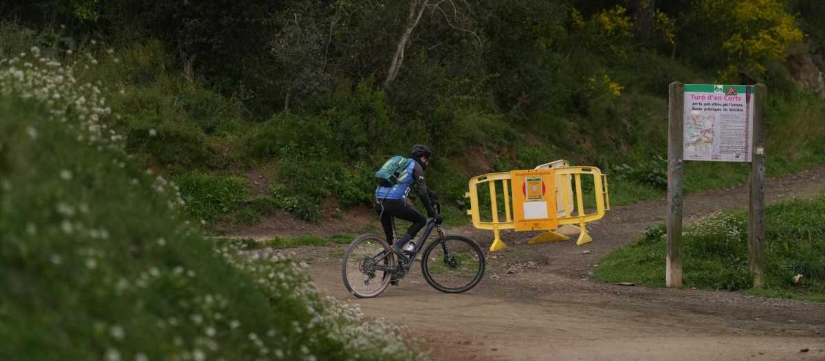 Un ciclista topa con una valla que prohíbe el acceso a Collserola, en una imagen de archivo