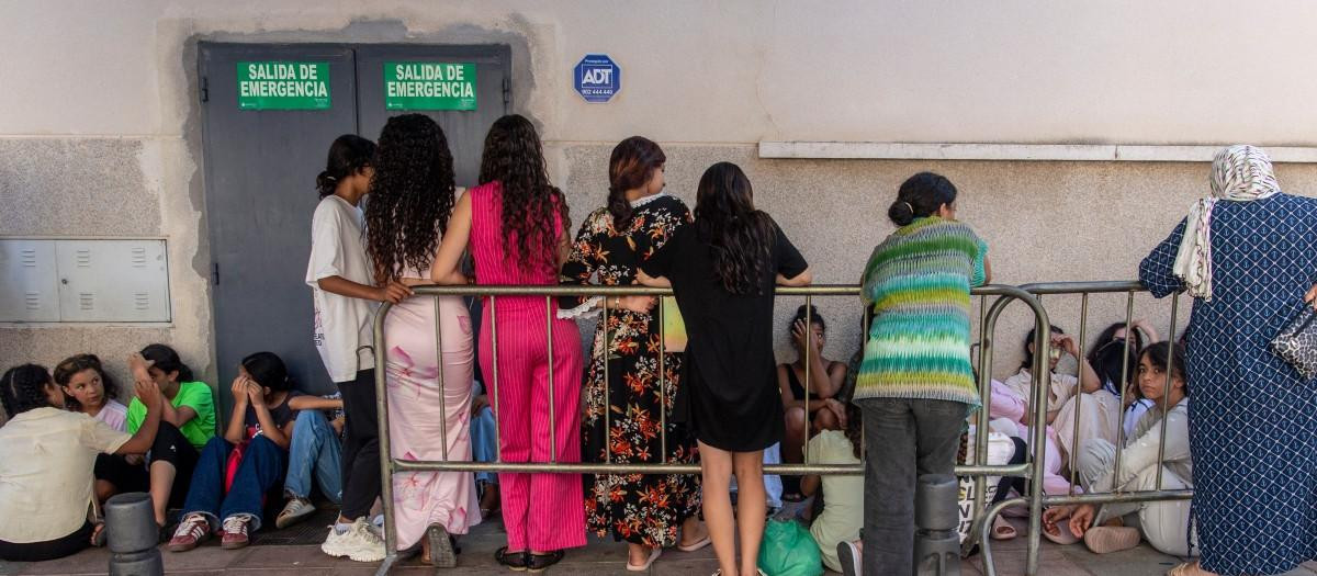 Menores inmigrantes aguardan frente a la sede de la Policía Nacional para iniciar los trámites de identificación y registro en el enclave español de Ceuta