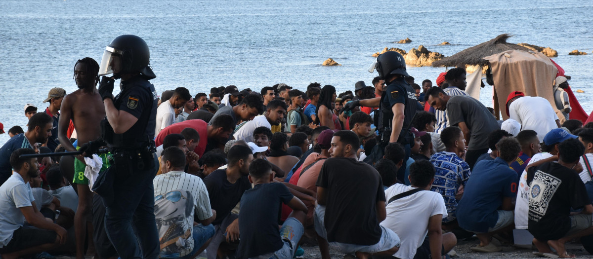 Cientos de personas migrantes en la playa del Trampolín, a 7 de agosto de 2026, en Ceuta