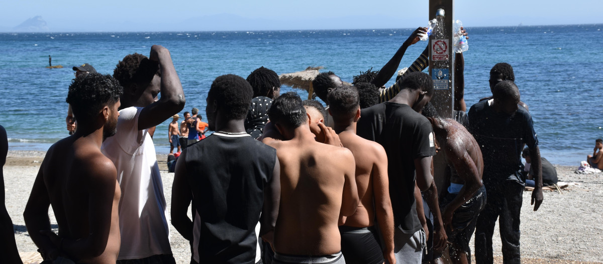 Varias personas se asean en las duchas públicas, en la playa del Trampolín, a 5 de agosto de 2026, en Ceuta