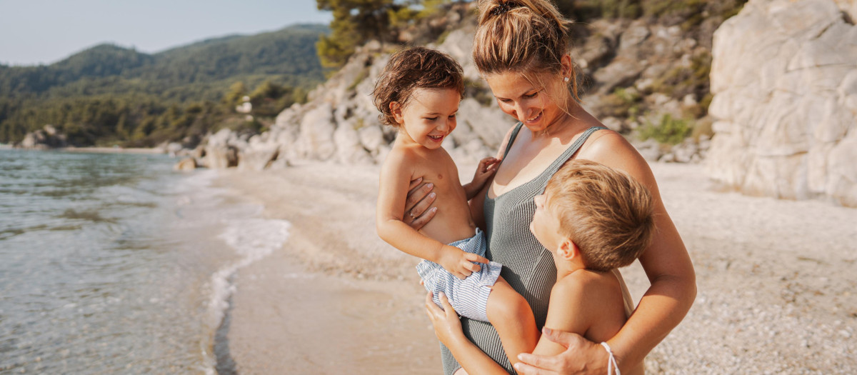 Una madre con sus dos hijos en la playa