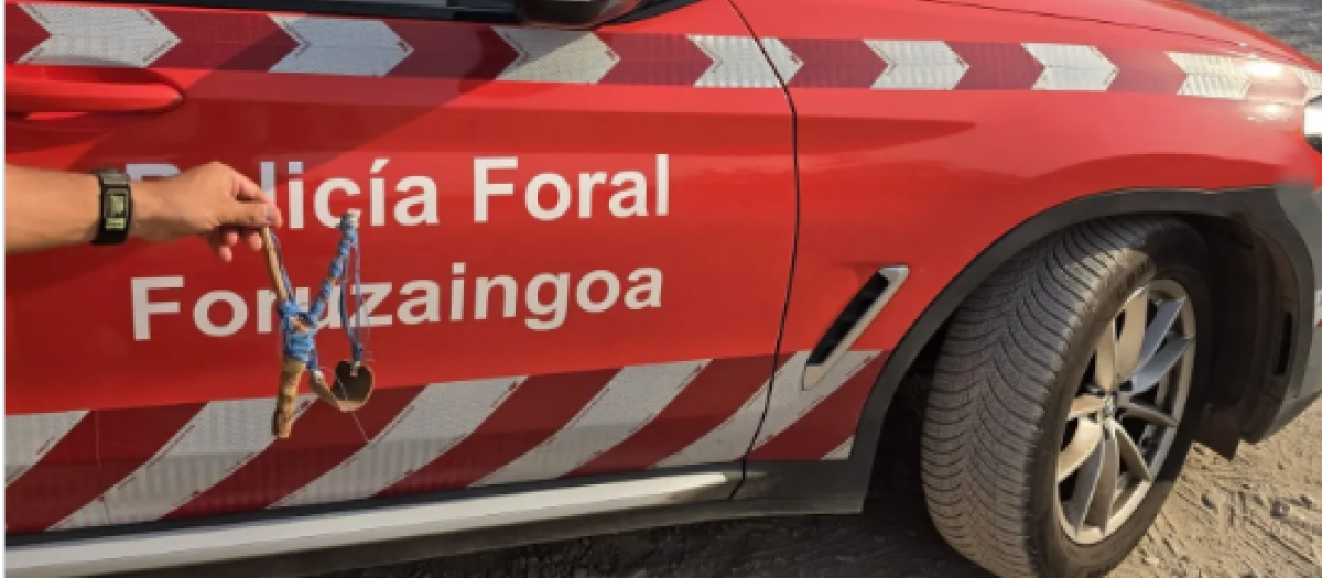 El coche de la Policía Foral participante en el incidente junto al arma
