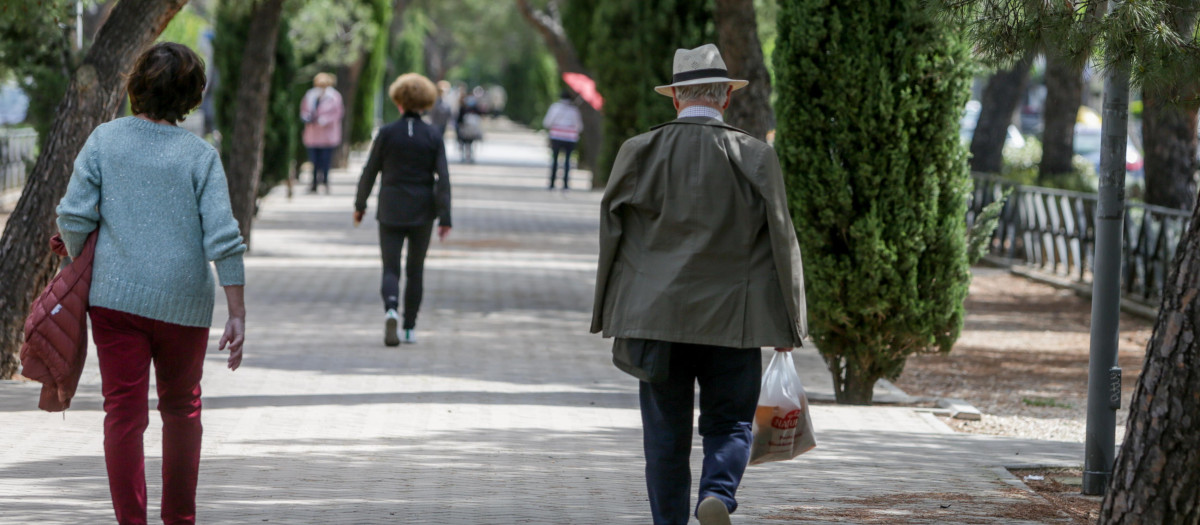Personas de avanzada edad caminan por un parque de Madrid