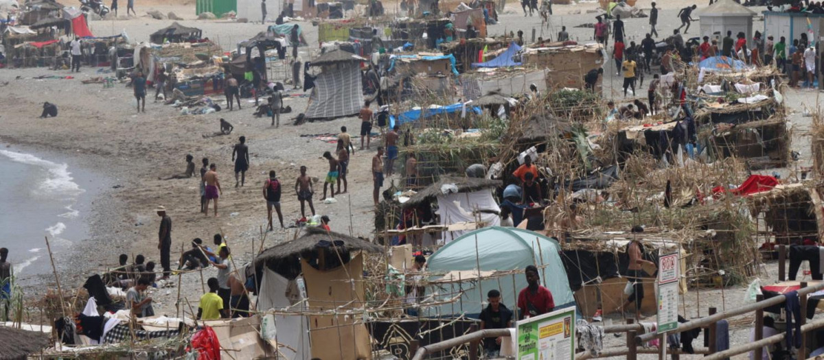 FOTODELDÍA - CEUTA, 14/08/2026.- Vista de la playa El Trampolín de Ceuta donde se encuentran cientos de los migrantes que llegaron a la playa del Tarajal. La entrada masiva de migrantes desde Marruecos a Ceuta, el 30 de julio, ha provocado una tragedia sin precedentes en esta frontera, con más de 70.000 personas que cruzaron a pie o nado al enclave español; 141 muertos, según organizaciones humanitarias, y tensiones entre Madrid y Rabat. EFE/Reduan