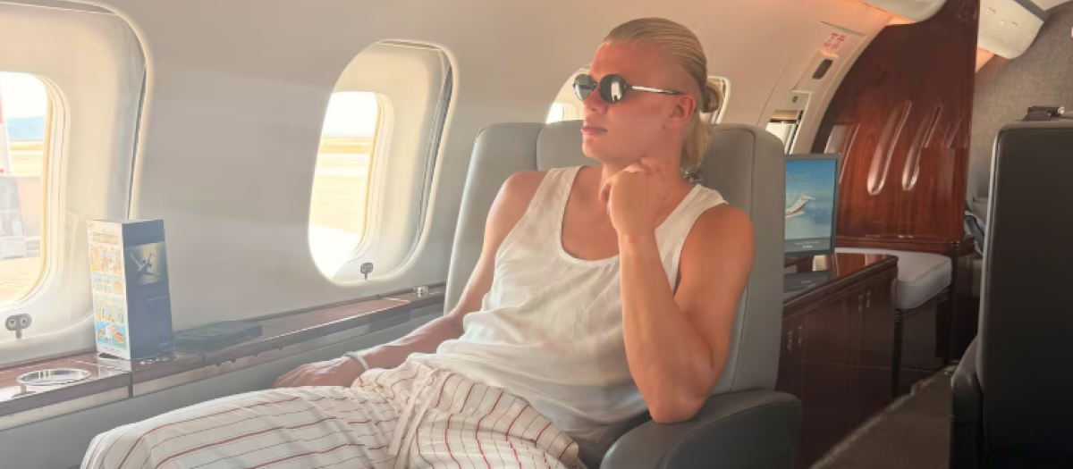 Haaland en un vuelo con las sandalias
