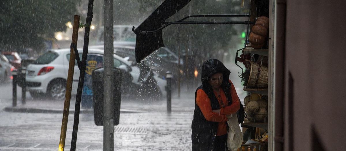 Una mujer con paraguas bajo la lluvia