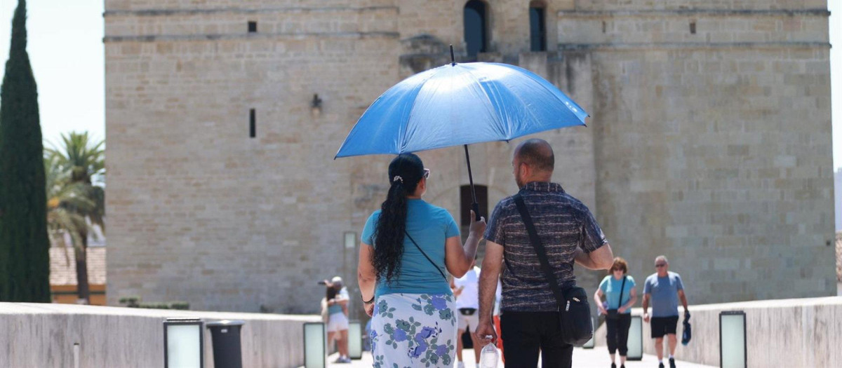 Dos visitantes de la ciudad se protegen del sol en el Puente Romano