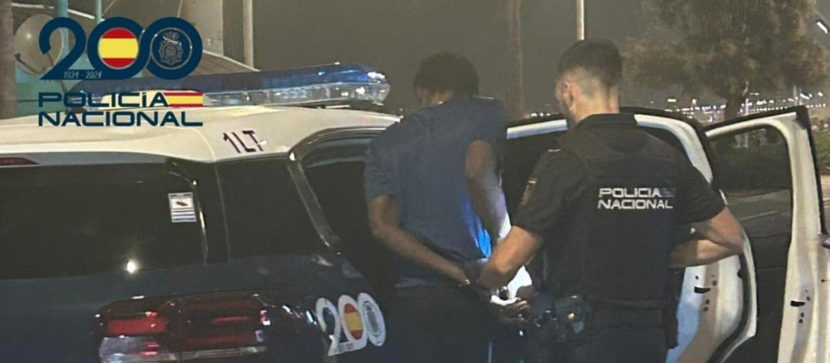 El detenido ingresa en una patrulla policial escoltado por un agente de la Policía Nacional..

La Policía Nacional ha detenido a un hombre por supuestamente robar a turistas en la Playa de Palma amenazándoles con navajas, piedras y botellas de vidrio fracturadas.

SOCIEDAD 
POLICÍA NACIONAL