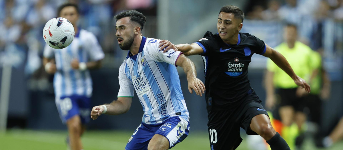 Carlos Puga, del Málaga, protege un balón ante Yeremay Hernández, de Deportivo