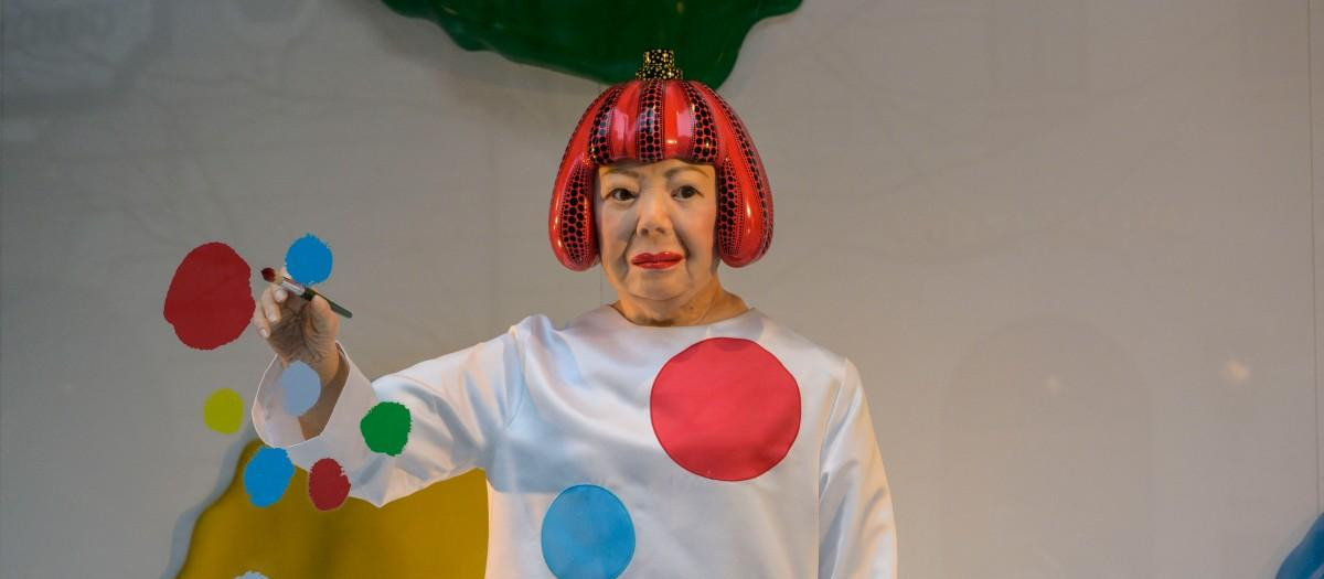 Un robot hiperrealista de la artista Yayoi Kusama pintando un escaparate