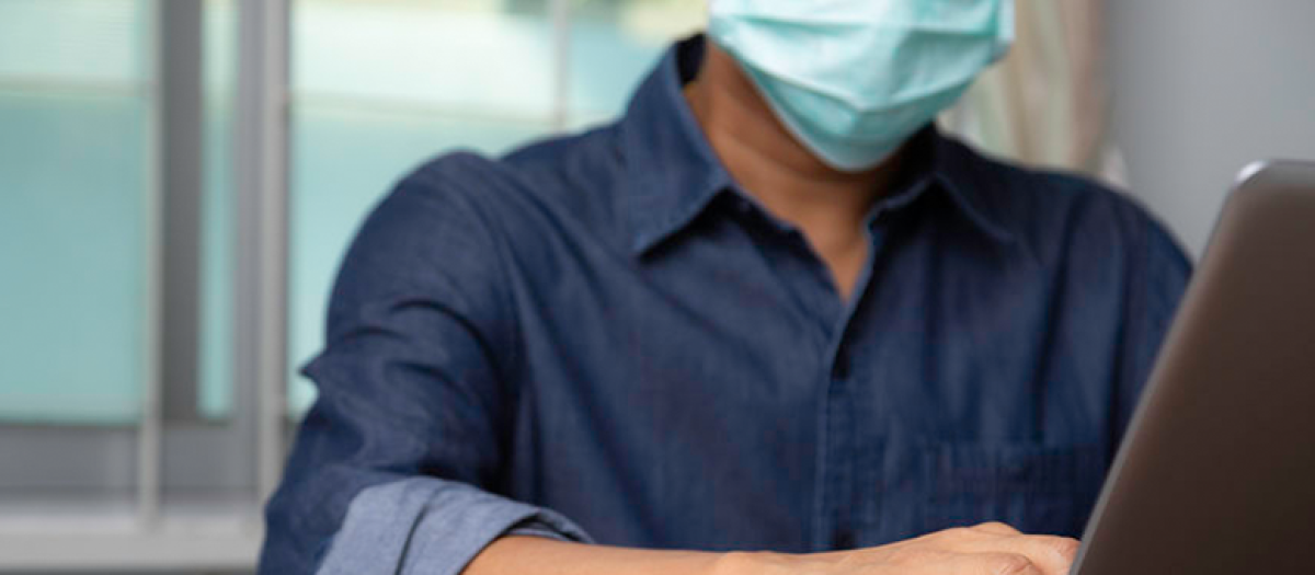 Imagen de archivo de un hombre trabajando con mascarilla durante la pandemia del covid-19