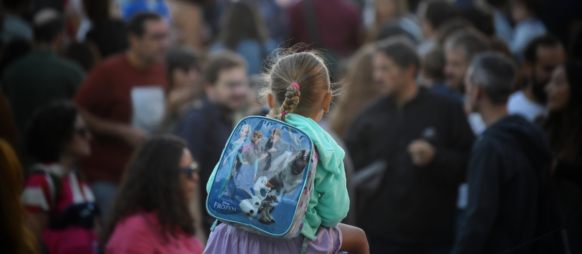 Una niña a hombros de su padre el primer día de colegio
