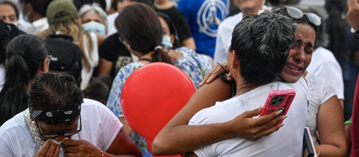 Varias personas se abrazan durante una misa con residentes y familiares de las víctimas del terremoto en los bloques de viviendas estatales de la OPP.