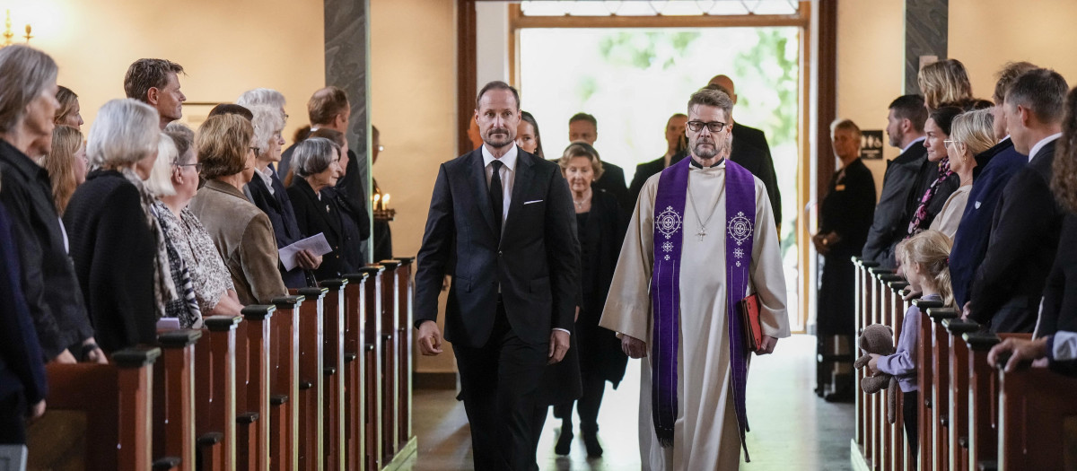 El rey Haakon VIII de Noruega, acompañado por el deán Oyvind Stabrun, camina por el pasillo para asistir al funeral de su padre el rey Harald V