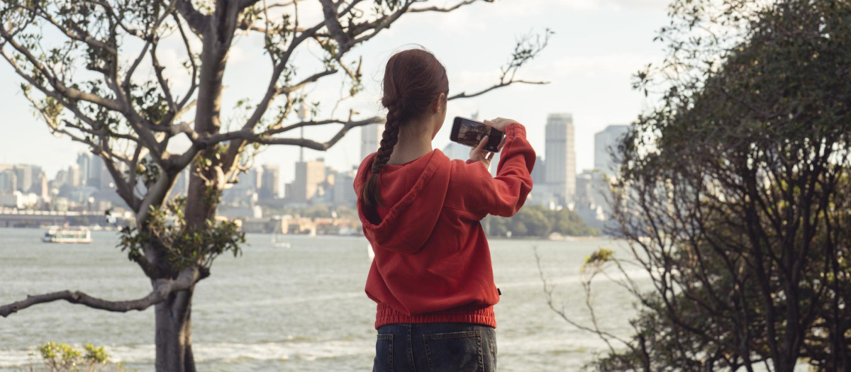Una adolescente graba un video del paisaje urbano de Sydney desde el mirador de Bradleys