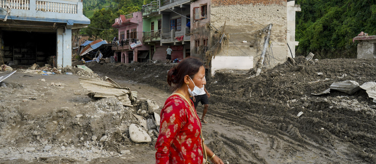 Una mujer camina este lunes por una zona afectada por una riada en Devighat (Nepal)